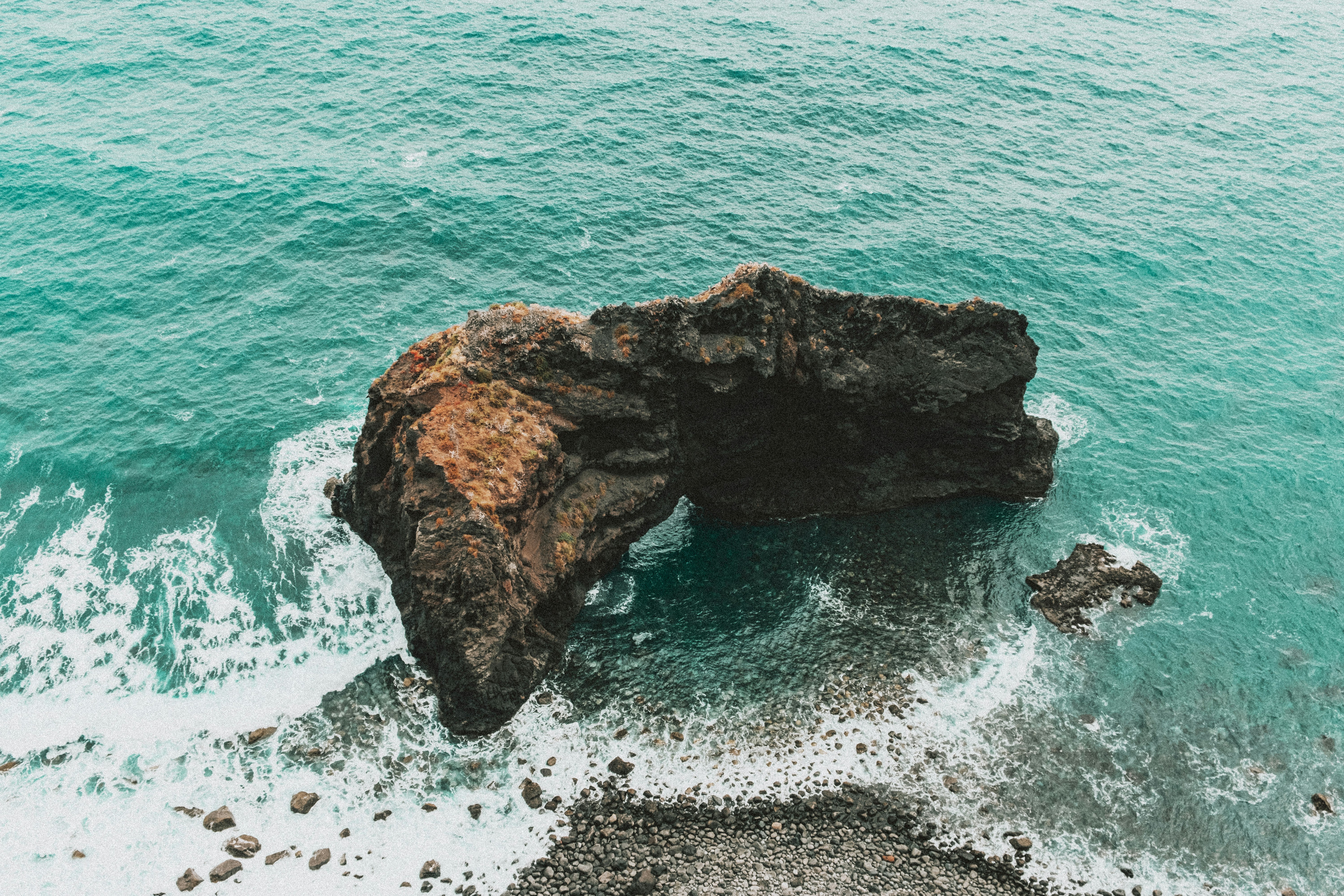 brown rock formation on sea during daytime